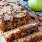 Sliced apple cinnamon bread with cinnamon sticks and Granny Smith apples in the background