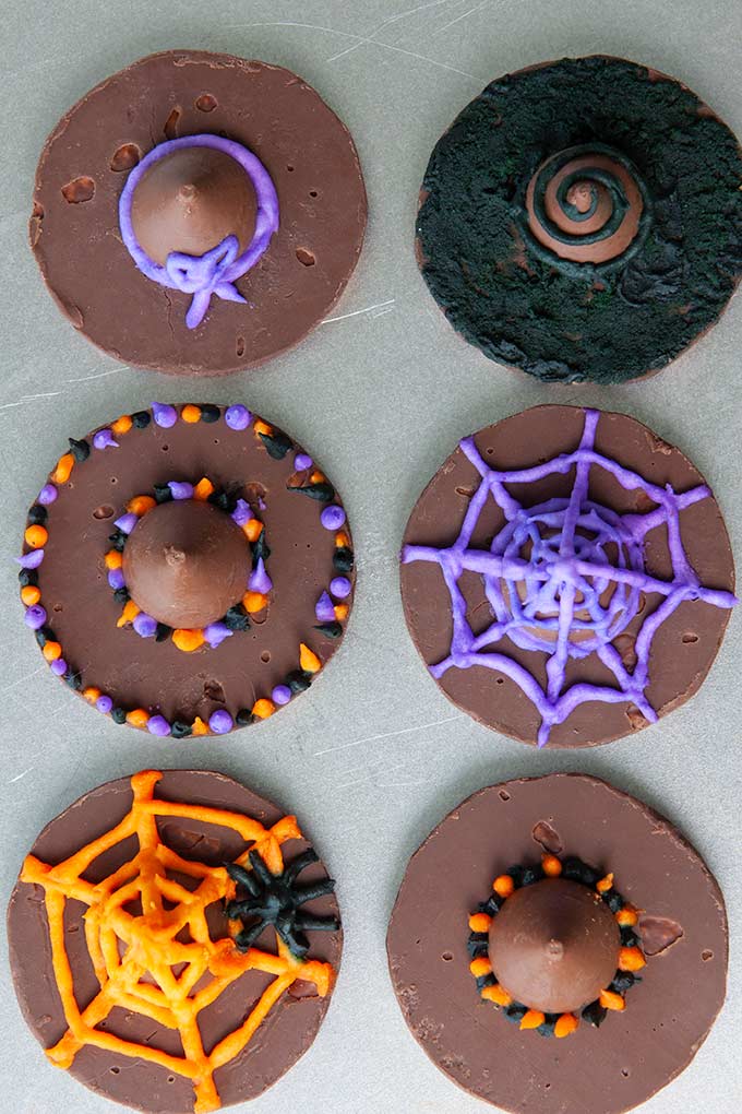 Above view of six cookie witch hats all decorated with purple, orange, and black frosting