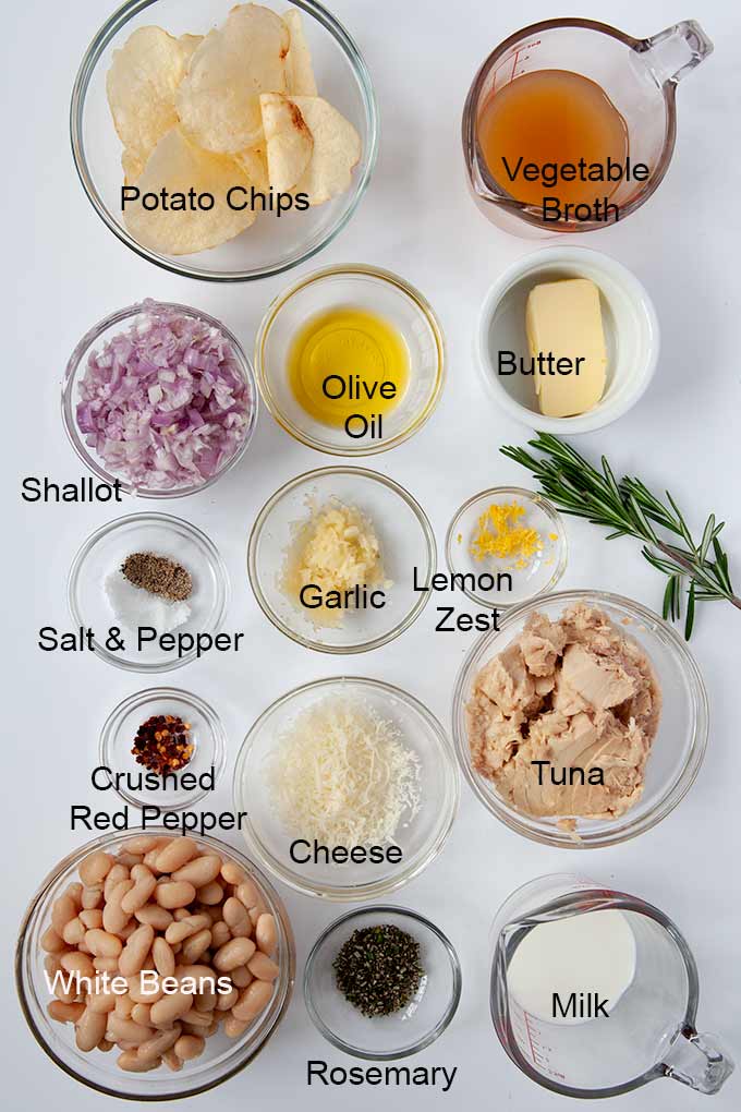 All of the ingredients to make tuna white bean casserole such as garlic, tuna, vegetable broth, white beans, and cheese