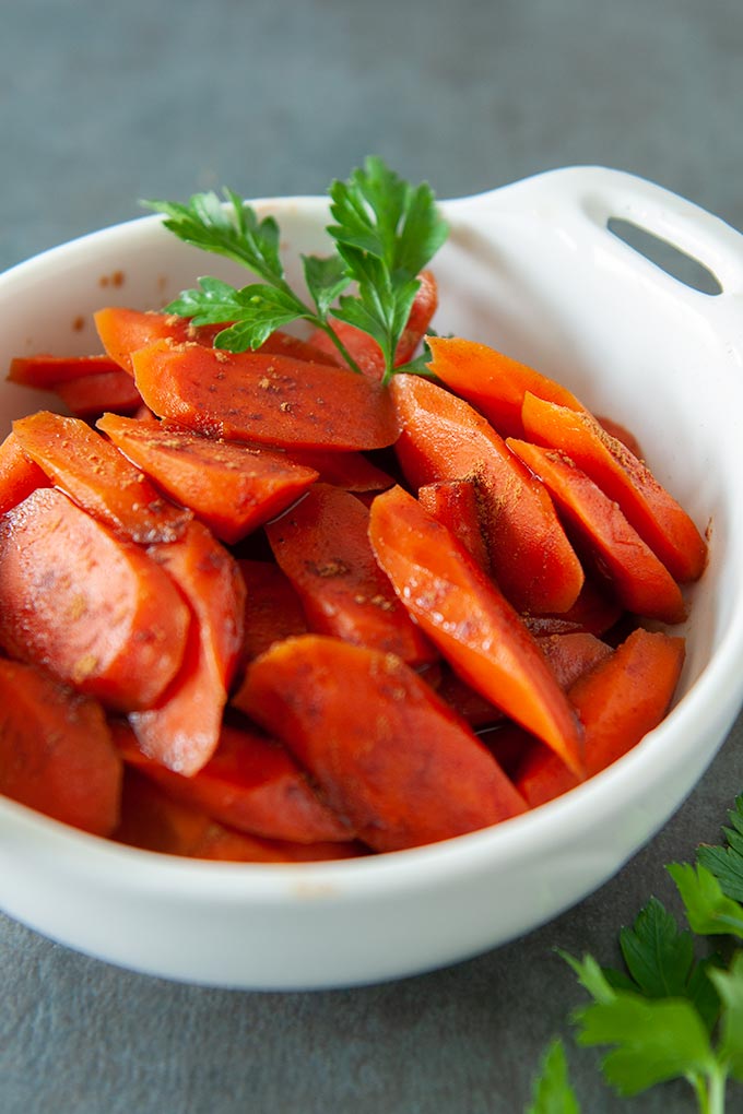 Carrots in a serving dish and two small serving dishes of carrots