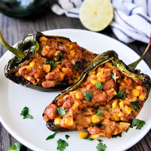 Up close plated poblano peppers sprinkled with cilantro and stuffed with pinto beans, cheese, and corn.