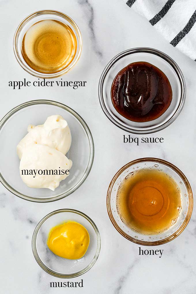 All of the ingredients needed to make Chick-fil-A sauce including barbecue sauce, honey, mayonnaise, apple cider vinegar, and mustard.