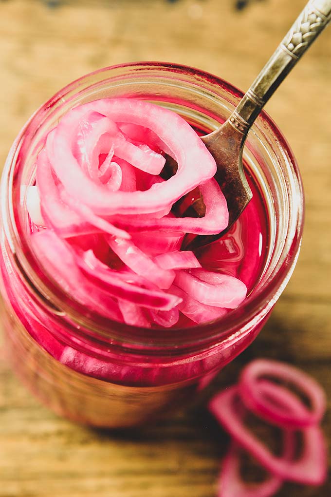 Above view of red pickled onion with a fork.