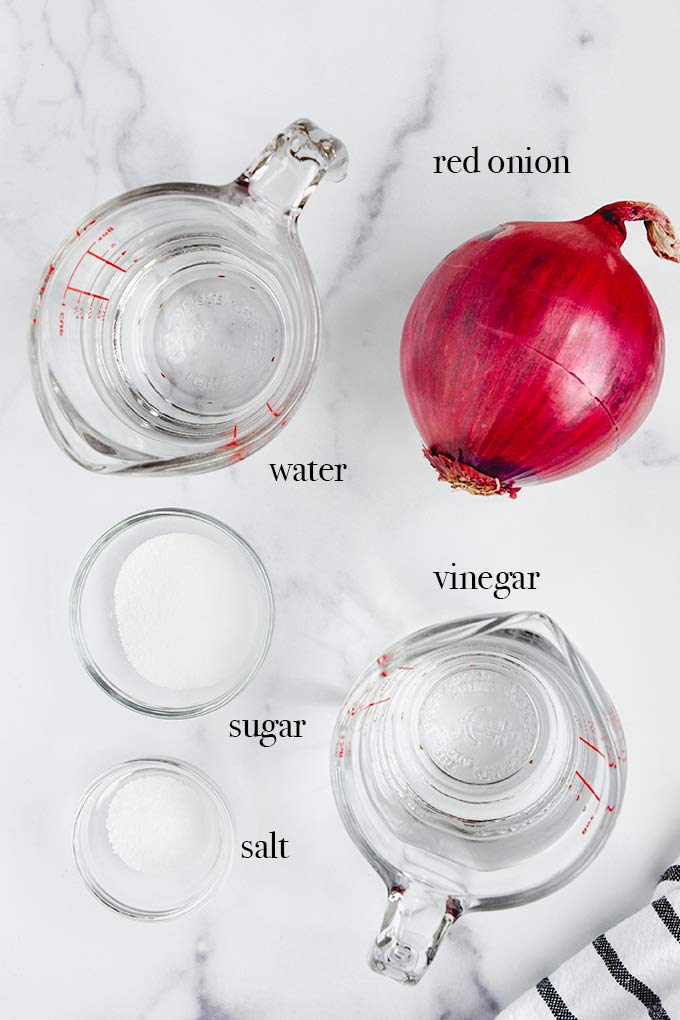 All of the ingredients needed to make pickled onions like red onion, vinegar and salt