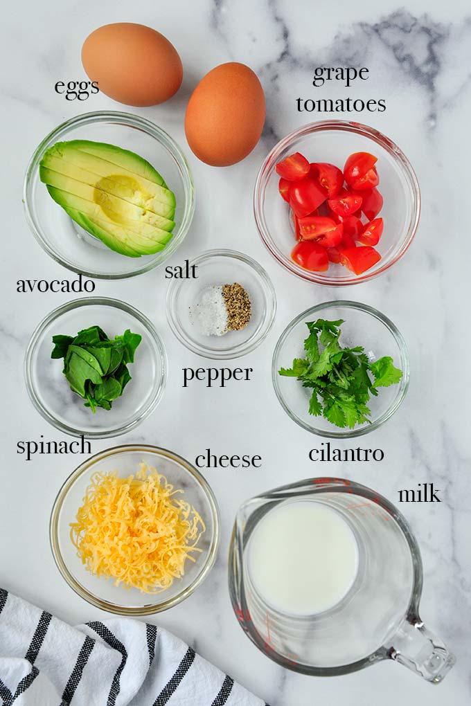 All of the ingredients needed to make omelet in a mug such as eggs, cheese, and milk