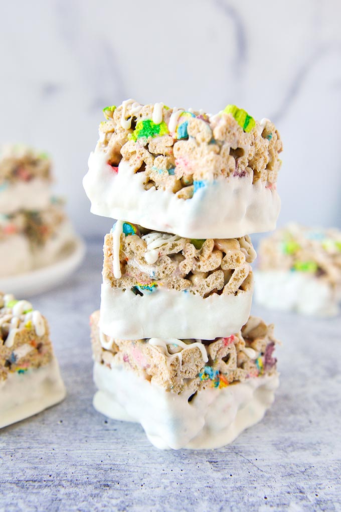 Stack of 3 cereal bars coated in white chocolate with bars around.