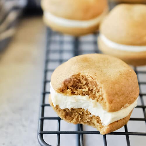 Fluffernutter cookie with a bite taken on a cooling rack with more cookies in the back ground.