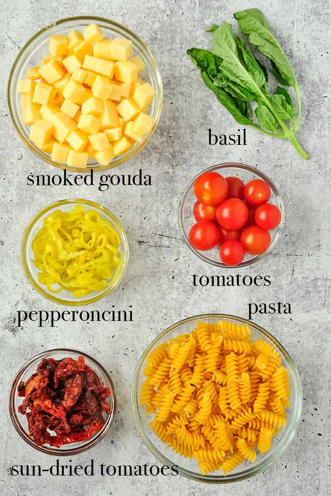 All of the ingredients needed to make pasta salad.