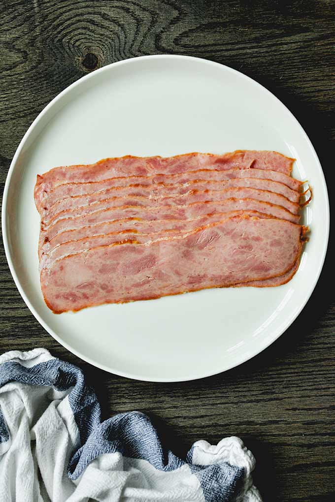 A plate with uncooked turkey bacon.