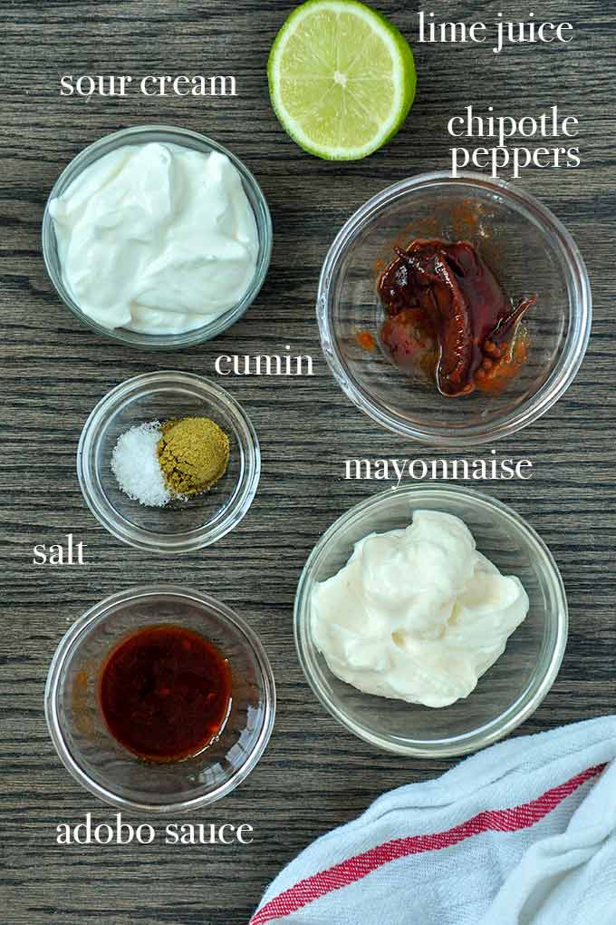All of the ingredients to make chipotle dip such as mayo, sour cream, adobo sauce, chipotle peppers, and cumin.