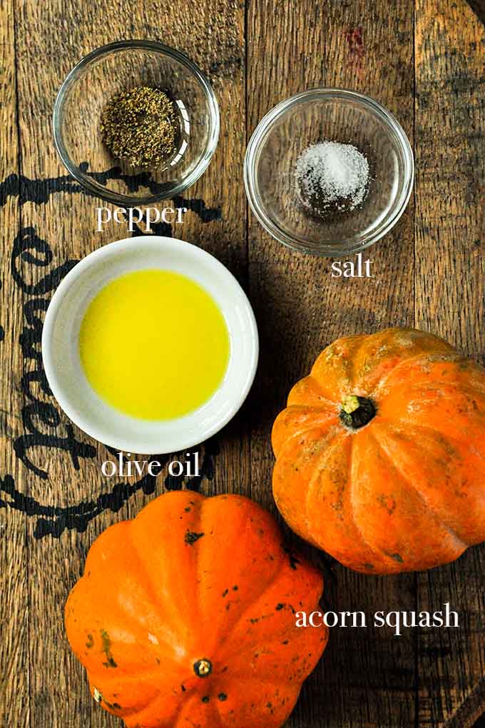 All of the ingredients to make air fryer acorn squash such as olive oil, salt, pepper, and acorn squash.