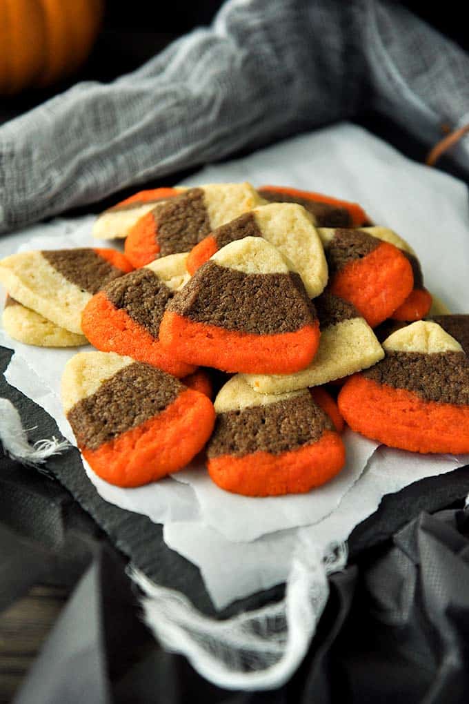 A tray full of candy corn cookies stacked on top of each other.