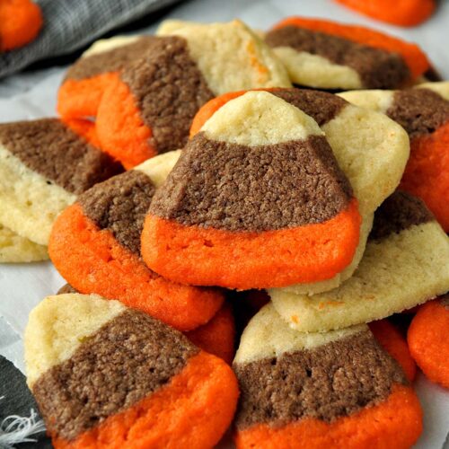 A tray full of candy corn cookies stacked on top of each other.