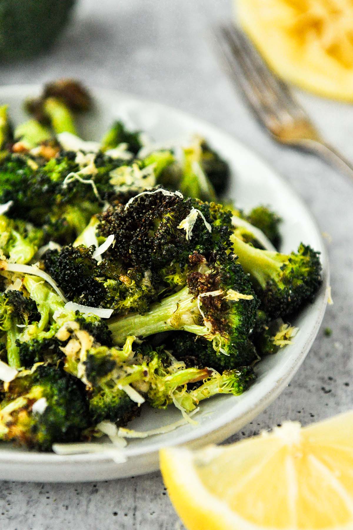 A plate of roasted broccoli with parmesan cheese.