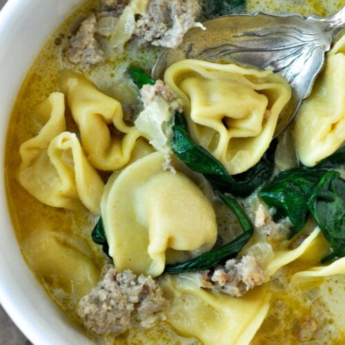 An up close view of Instant Pot Tortellini Soup with a spoon.