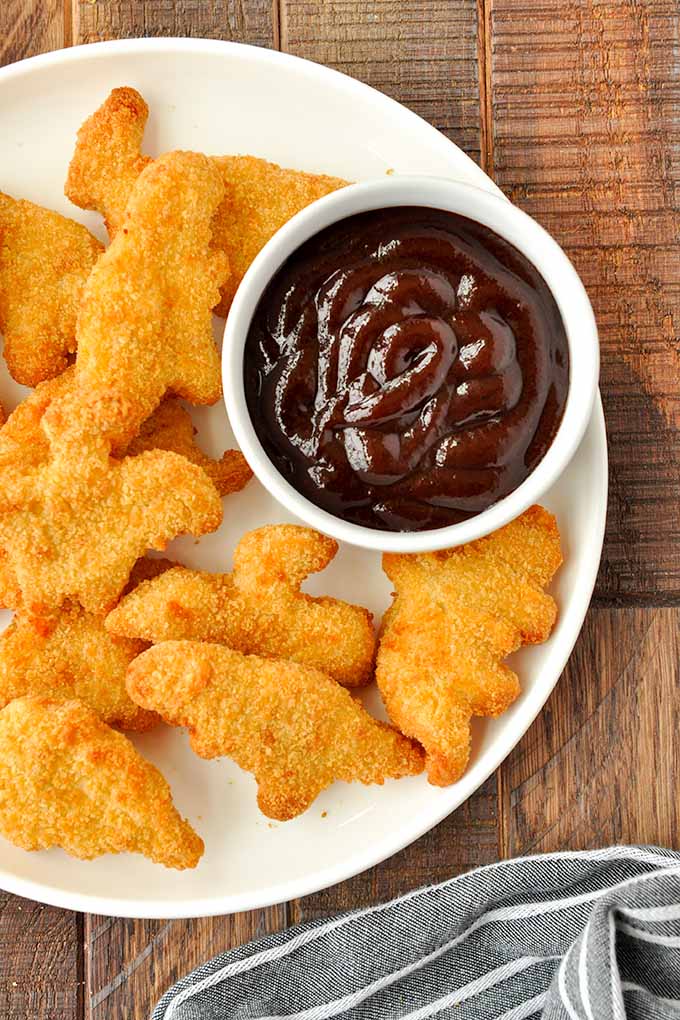 An above view of a plate of air fryer dino nuggets and dip.
