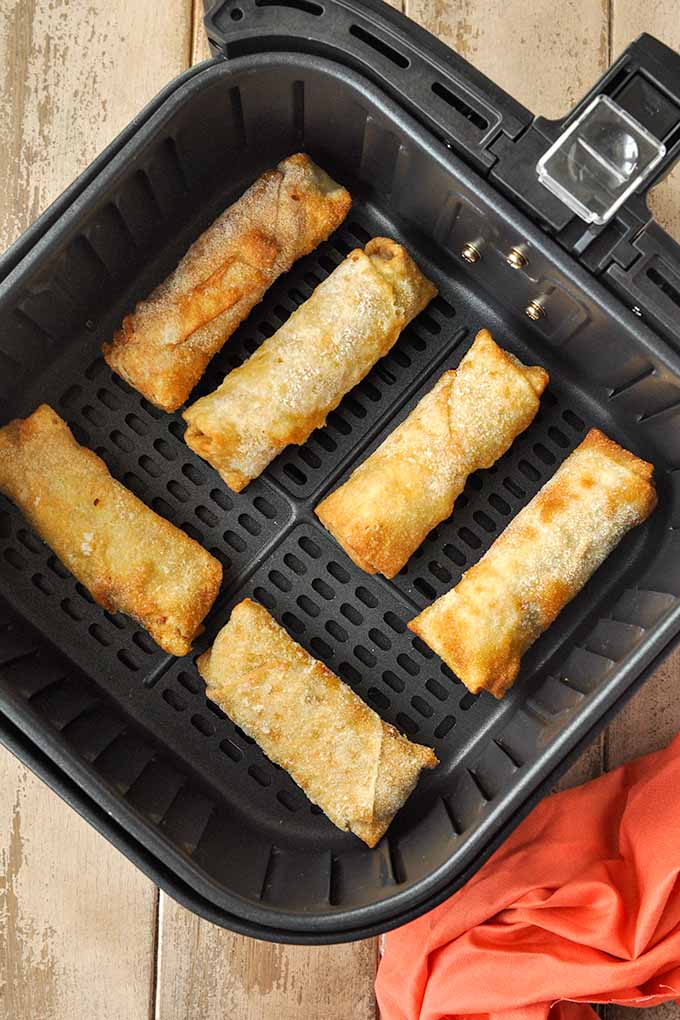 Step by step instructions for cooking frozen egg rolls in air fryer.