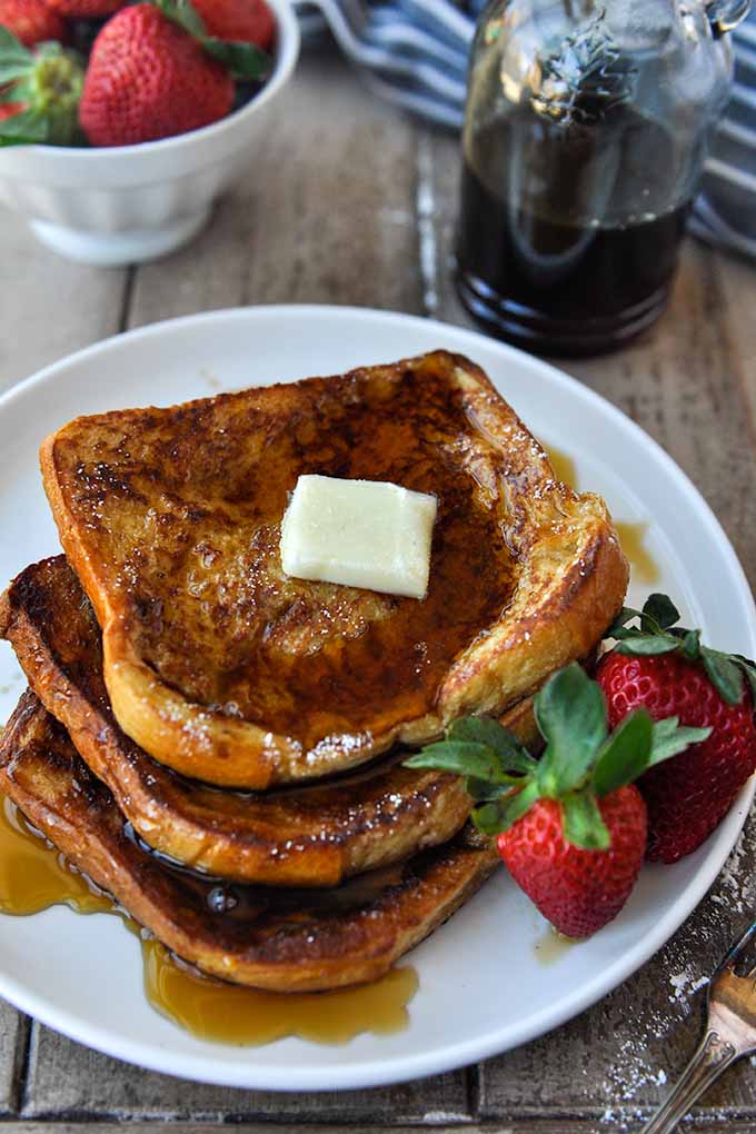 A plate of McCormick French toast with butter and syrup.