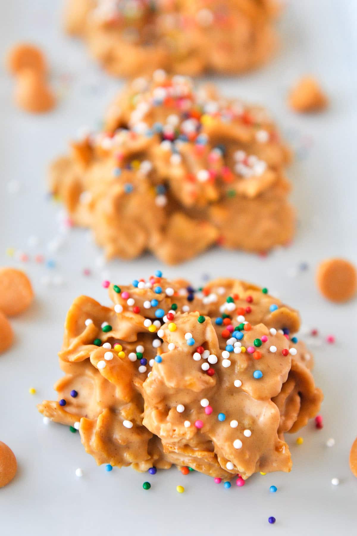 An up close of butterscotch cornflake cookies topped with sprinkles.