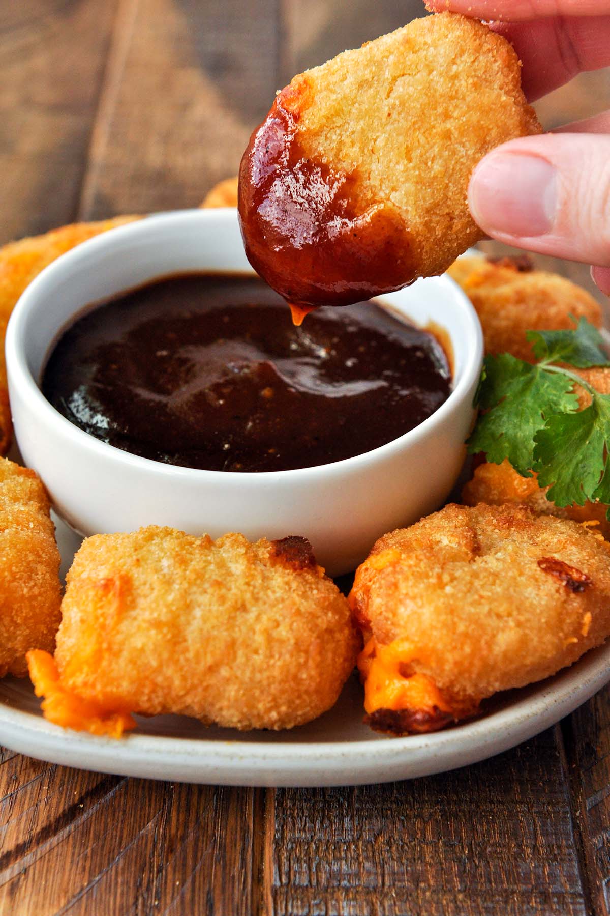 A air fried mac and cheese bite that's been dipped into dipping sauce.
