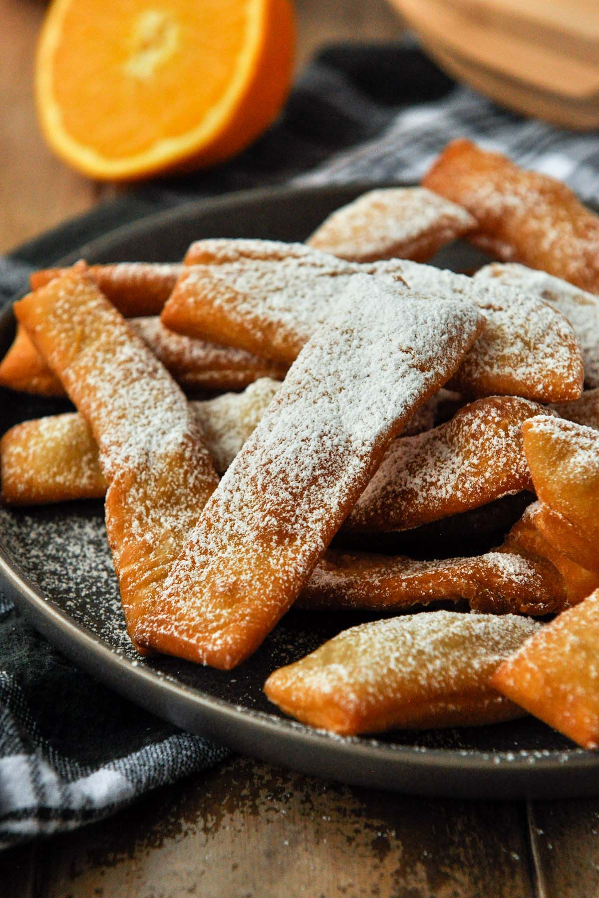 Up close of a plate of hojuelas that has been dusted with powdered sugar.