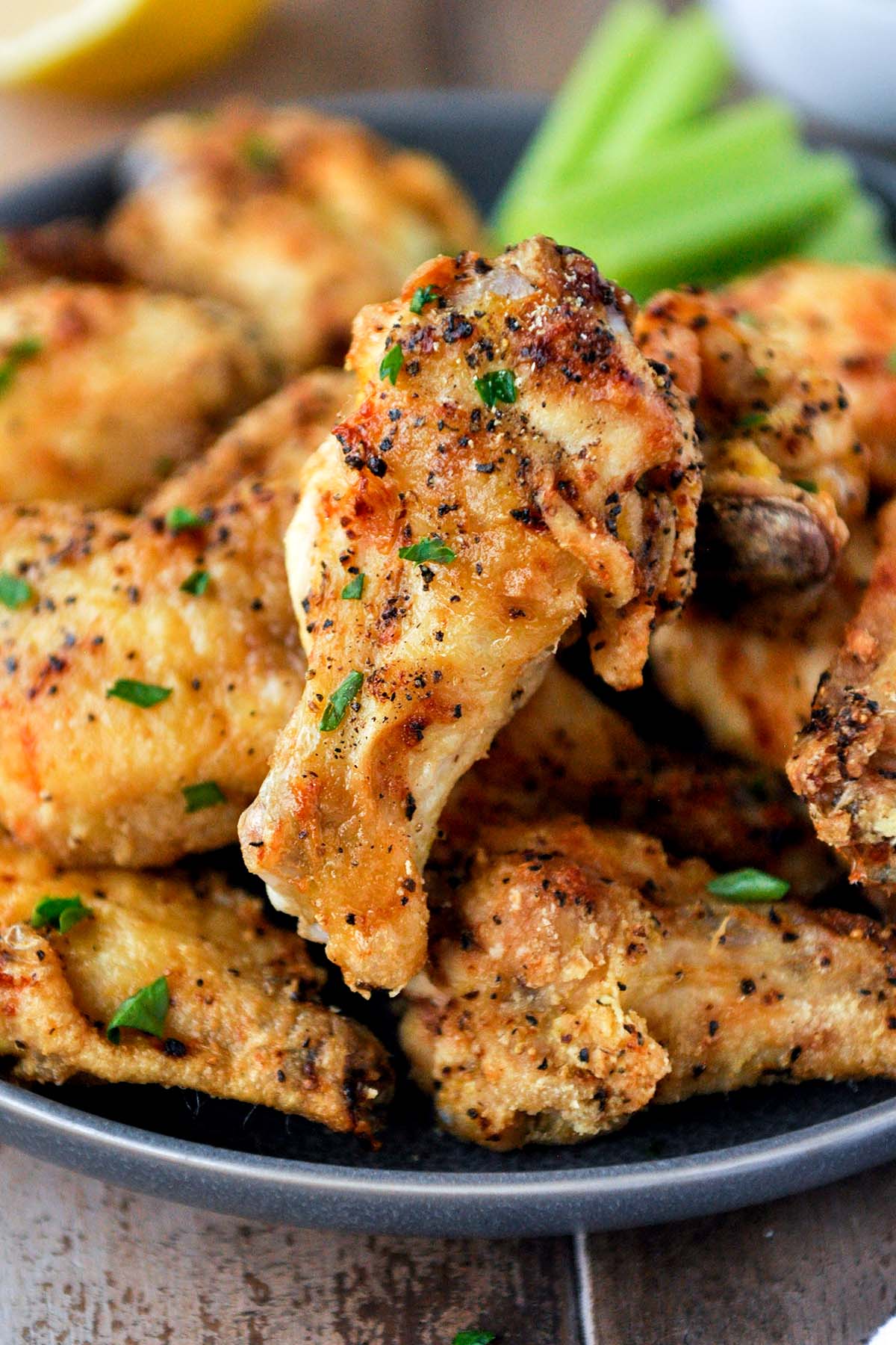 Close up of air fryer lemon pepper wings on a plate.