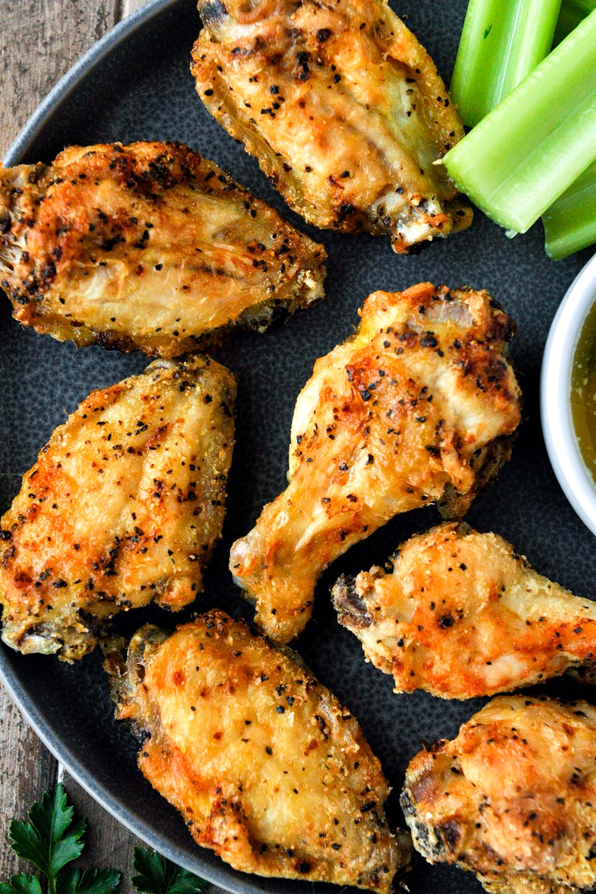 Above view of lemon pepper wings on a plate with celery and dipping sauce.