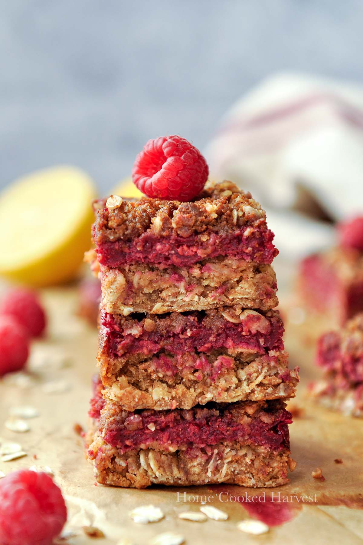 A stack of three fruit bars with a raspberry on top.
