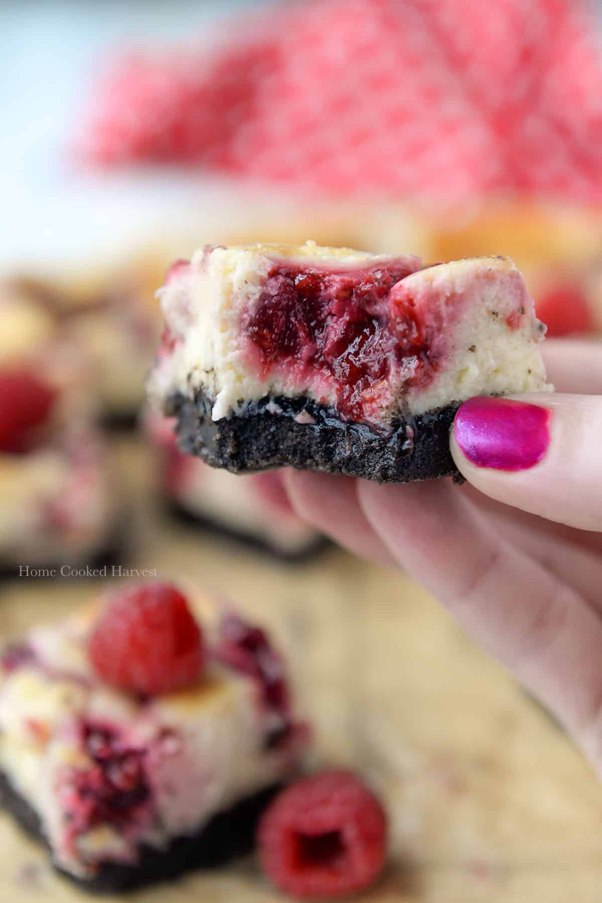 A raspberry bar with a bite missing being held.