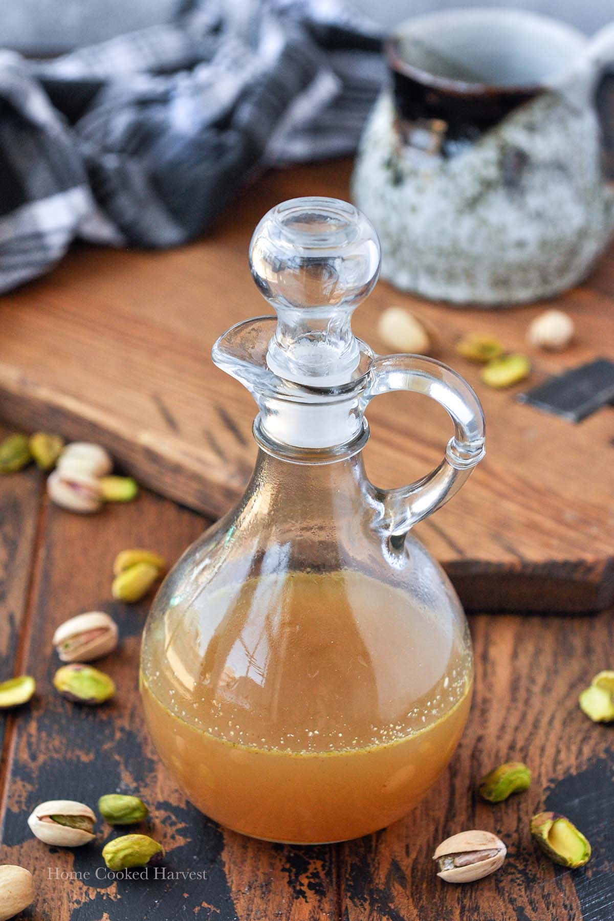 A glass jug filled with pistachio coffee syrup.