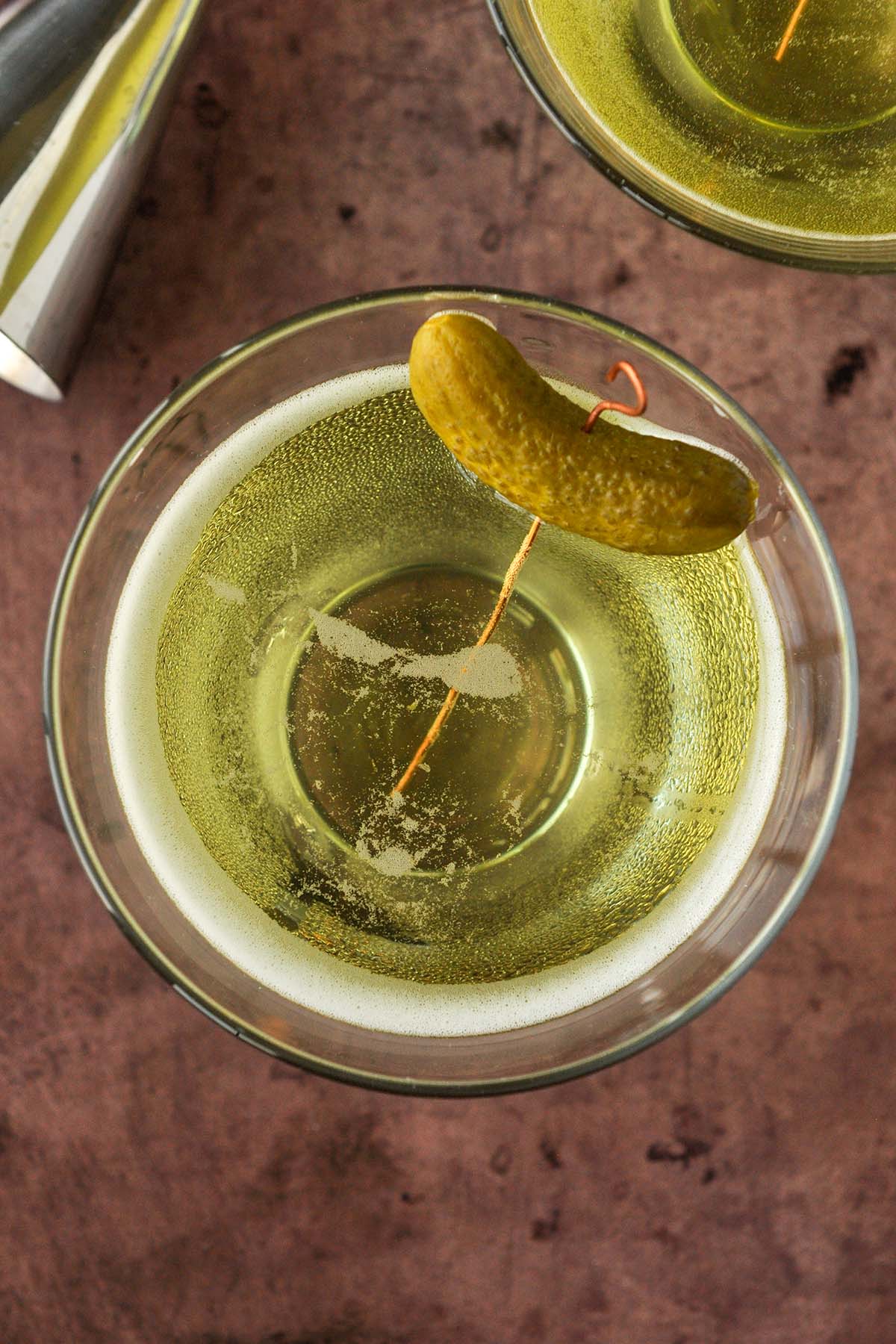 Above view of pickle juice martini  with a pickle garnish.