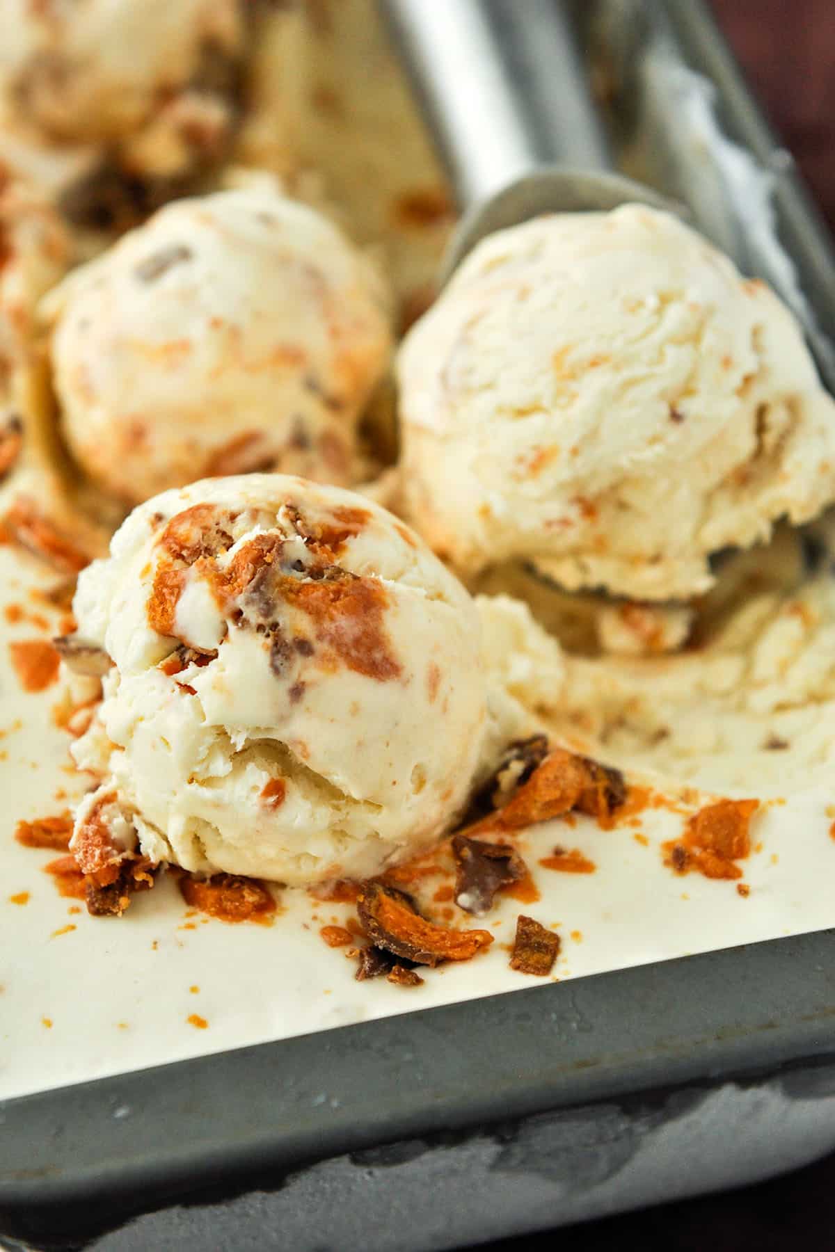 Up close of scoops of butterfinger ice cream.