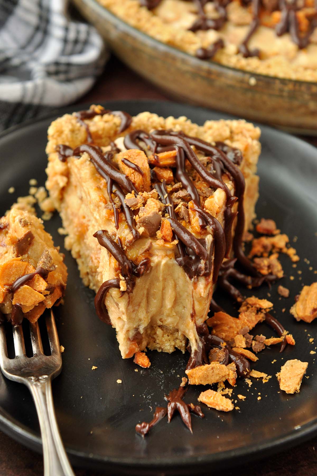 An up close slice of butterfinger pie with a bite taken with a fork.