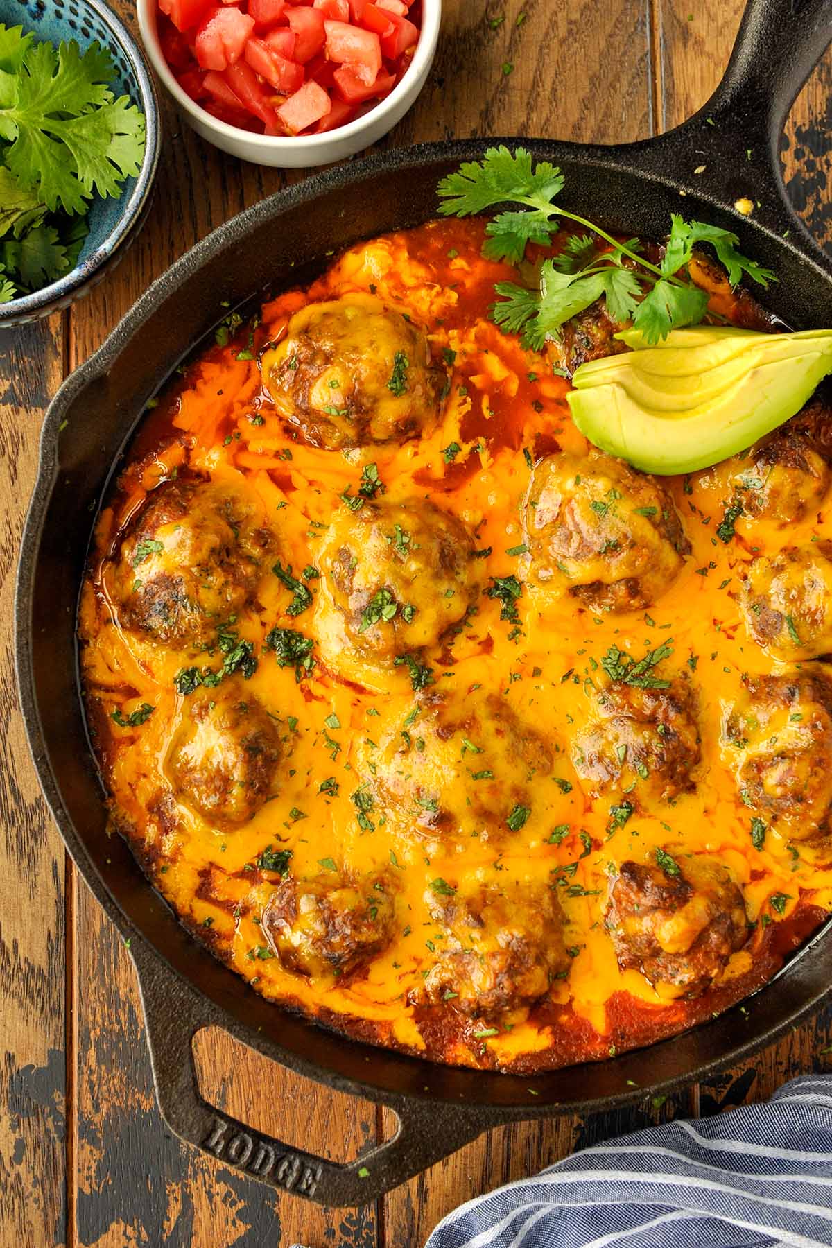 Above view of a skillet full of cheesy meatballs.