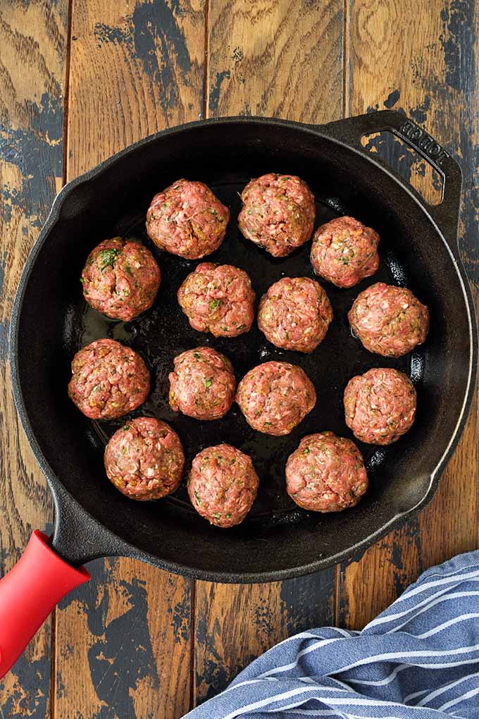 Step two to make meatballs is to form them into 2-inch balls and place them in hot oil in pan.