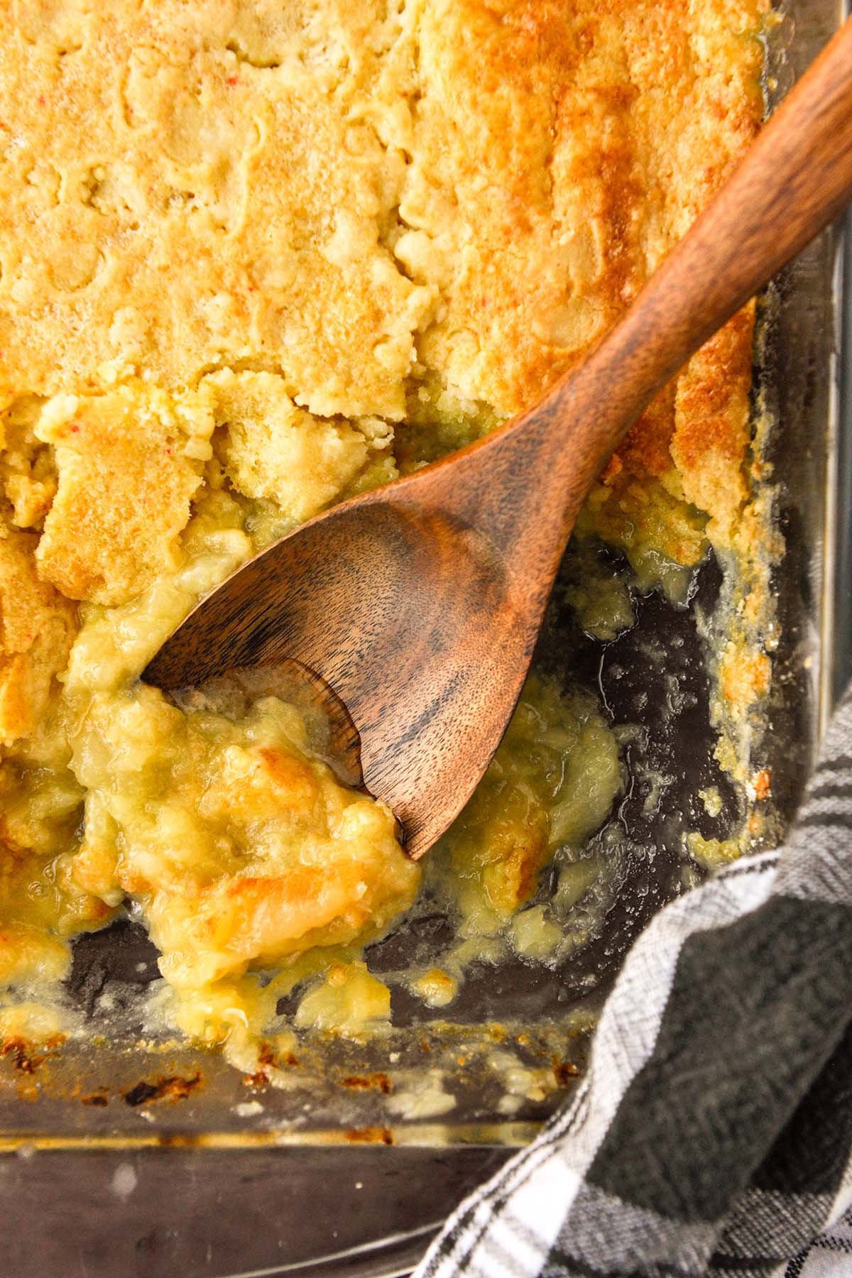 Above view of pineapple dump cake in a pan with a spoon