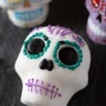 An angled view of a decorated sugar skull and two skulls in the background.