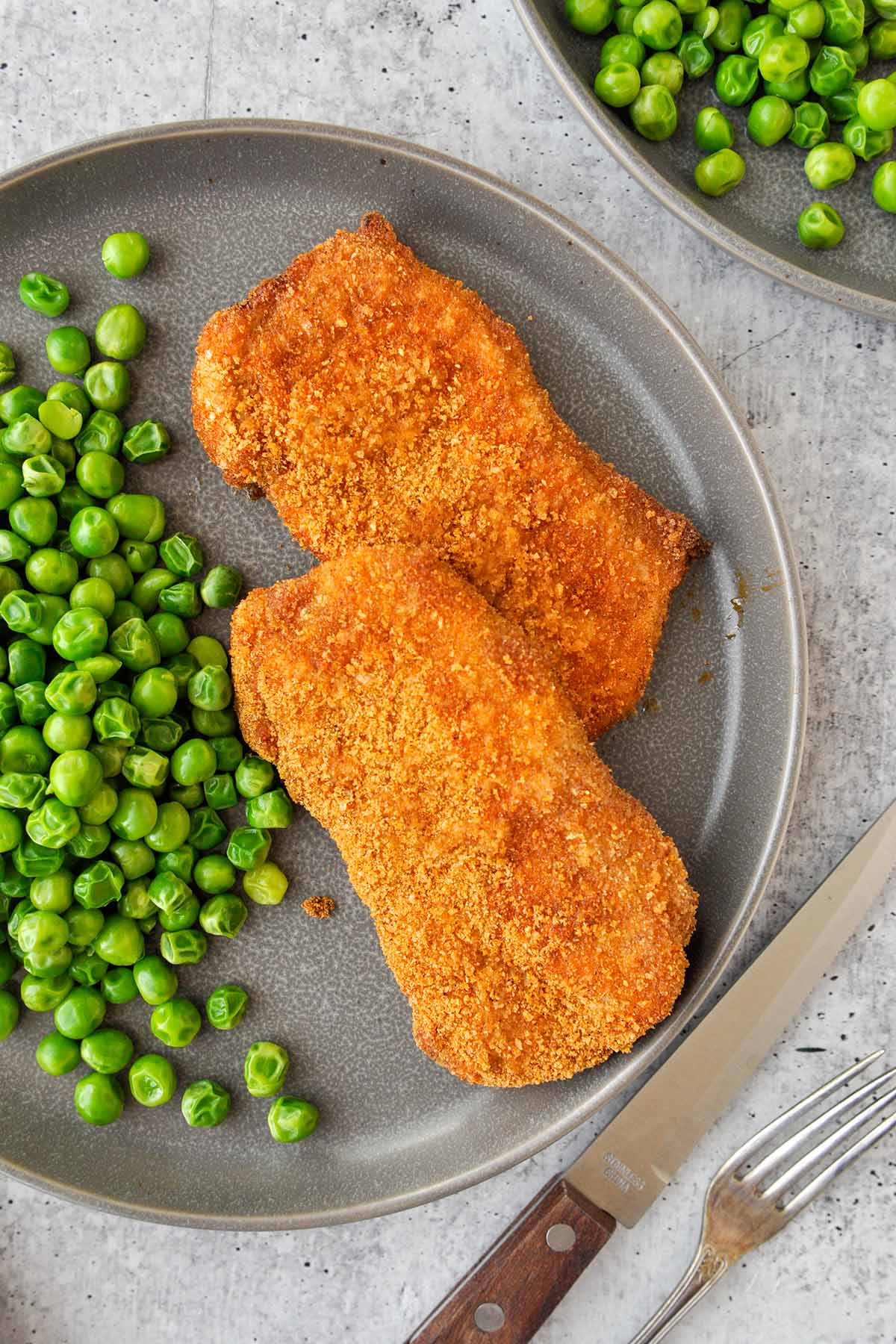Above view of a plate of air fried bake chops and peas.