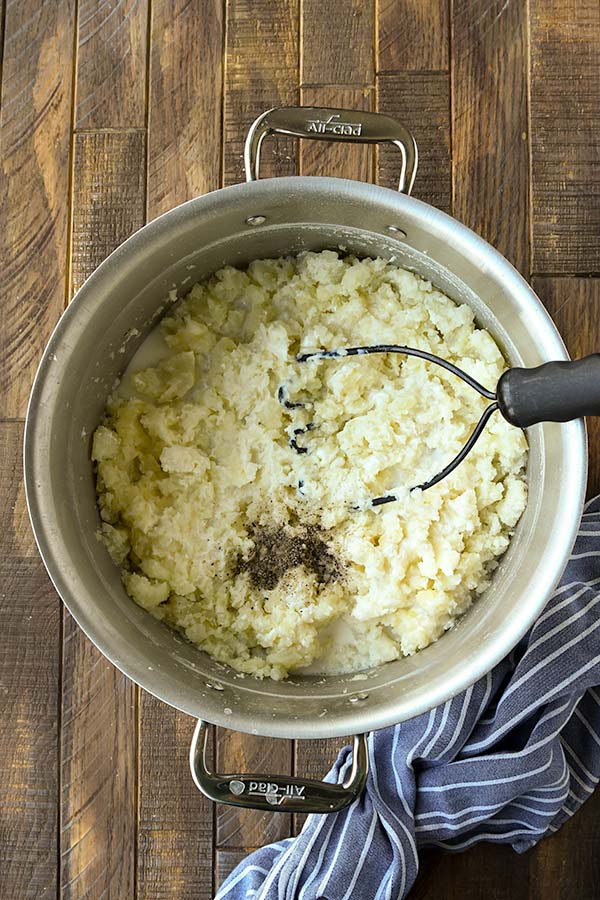 The final step is to add seasonings, dairy, and smash until the potatoes are creamy.