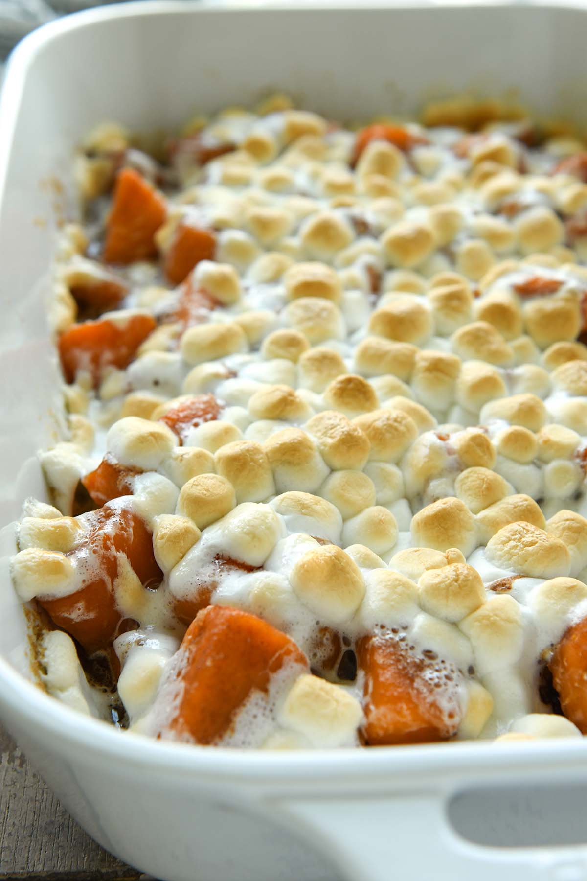 A large baking dish of candied yams covered in marshmallows.
