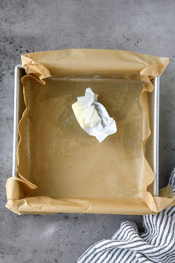 Step one is the metal baking pan lined with parchment paper and being buttered.
