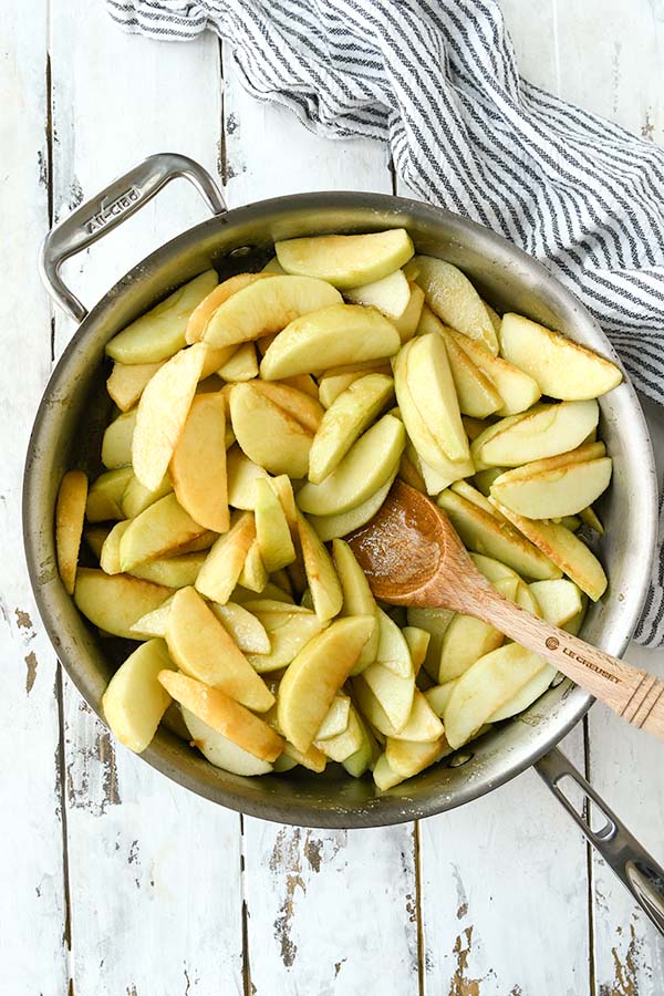 Step two is a pan of cut apples cooking in butter sauce.