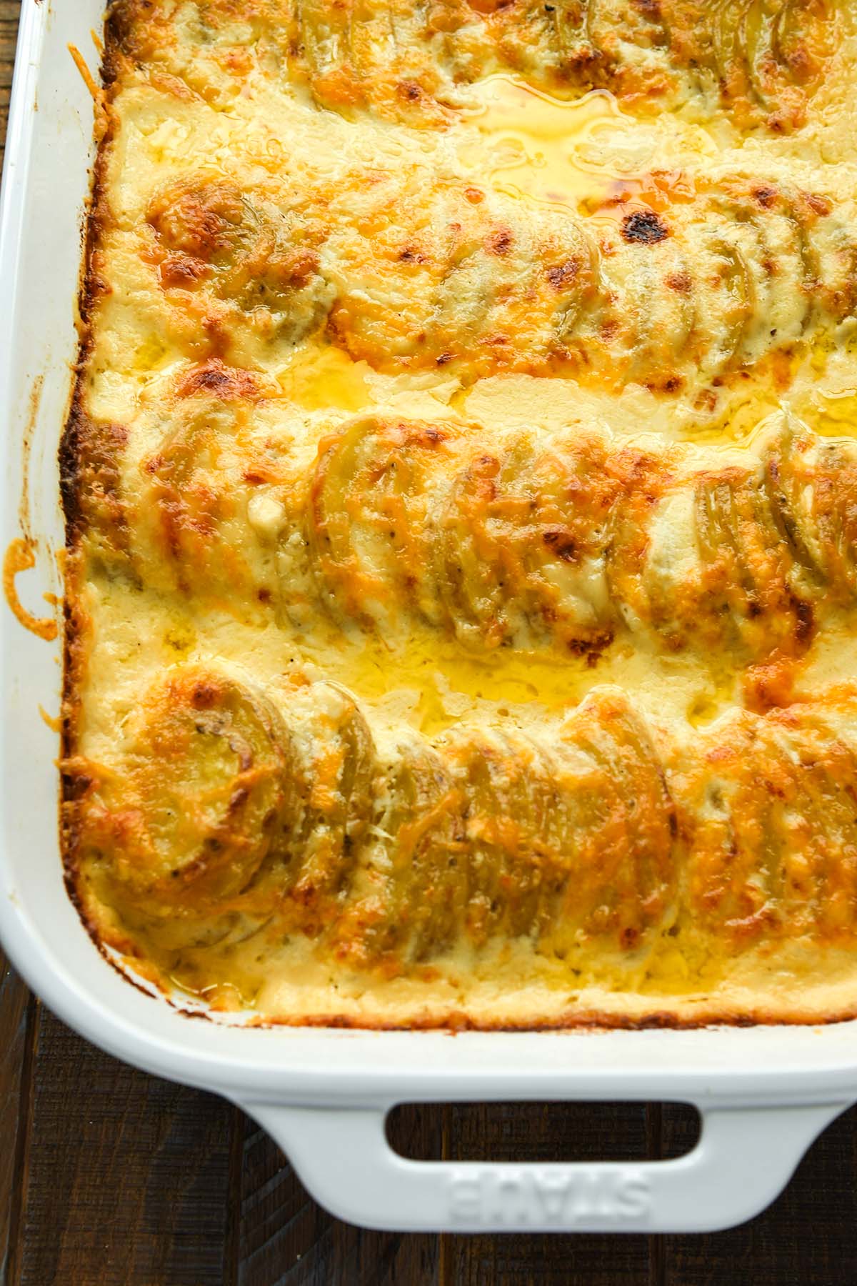 Above view, close up of a white dish of potatoes au gratin.
