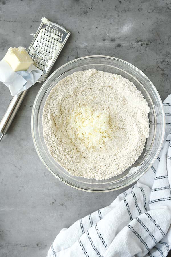 Step two is a large bowl with the flour, spices, baking powder, baking soda, and salt whisked together. And the frozen butter grated in.