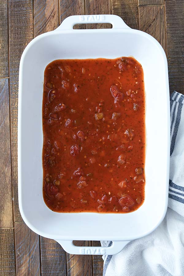 Step five is a baking dish with the enchilada sauce and the salsa added.