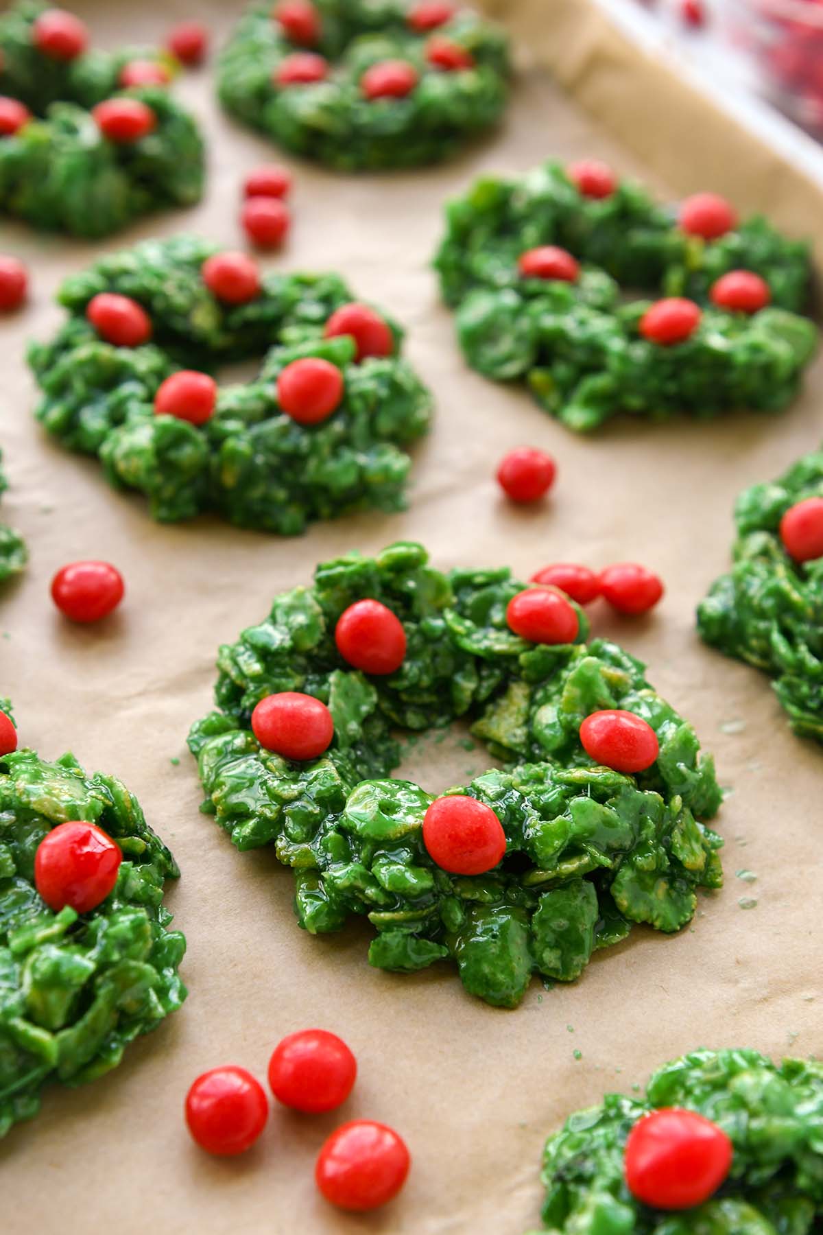 A baking tray with cornflake wreaths on top of brown parchment paper.