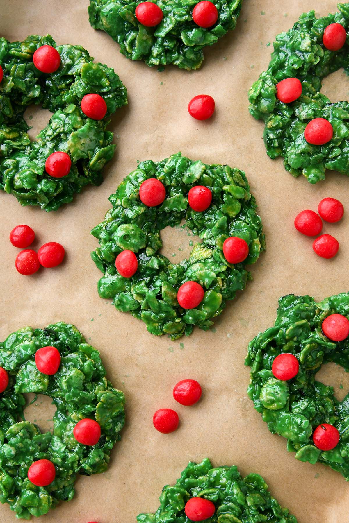 Above view of wreaths on a baking sheet with extra cinnamon candies around.