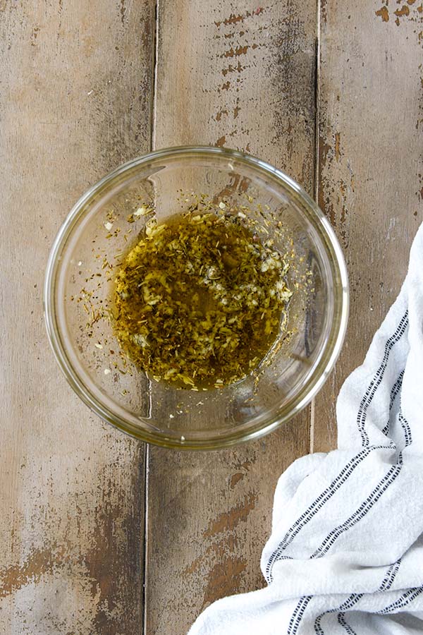 Step two is combining together the oil, seasoning, garlic, salt and pepper.