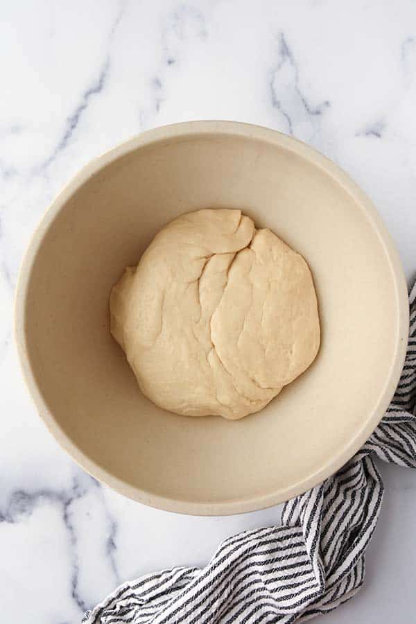 Step four is adding the dough ball to an oiled bowl to let it rise.