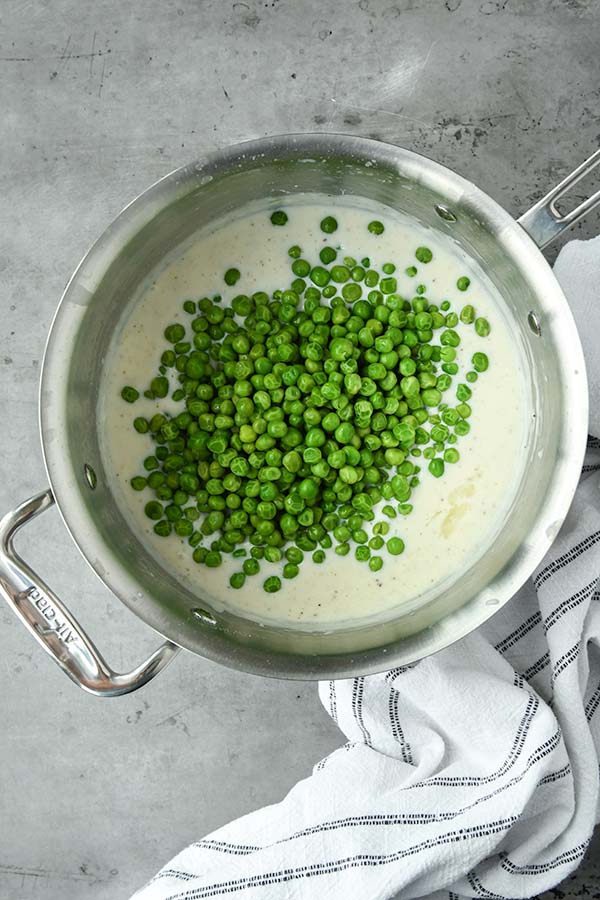 Step four is adding the peas to the sauce in a pan.